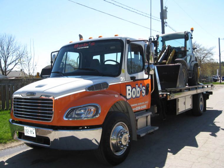 serving guelph & surrounding area since 1981 [orange and white tow truck]